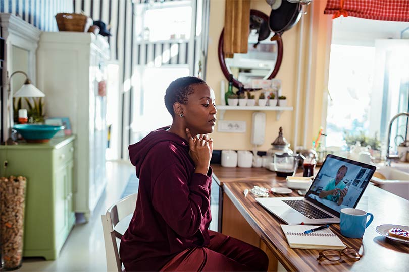 A woman in her home having a virtual telehealth appointment with her healthcare provider, discussing the relationship between diabetes and thyroid health.