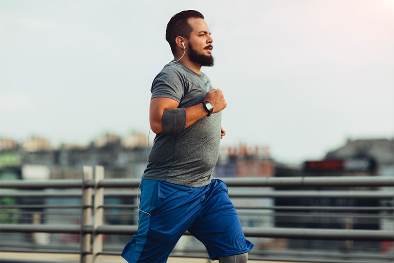 An adult man running outside, working on healthy habits to manage diabetes and weight loss.