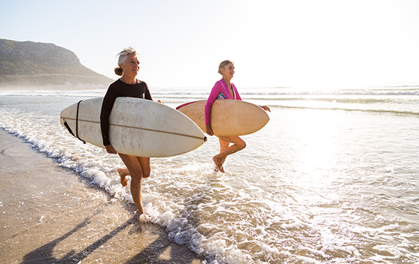 Senior women going for a morning surf in the sea