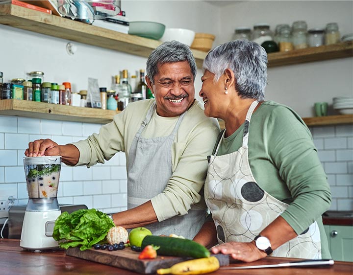 senior couple preparing a healthy smoothie in the kitchen at home