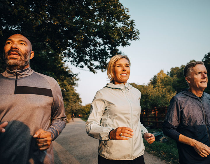 A group of people is seen jogging on a road in the evening