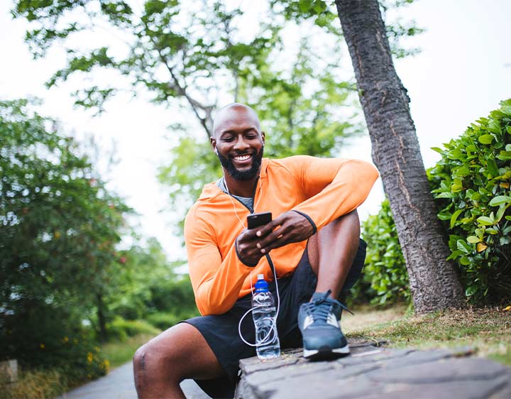 Individual smiling while exercising and drinking water.