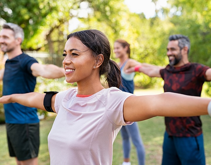 A group of people stretching outside focused on their hormone health.