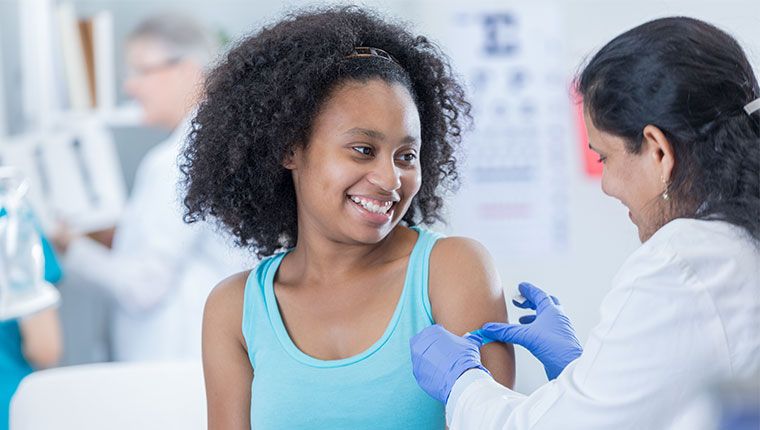 A woman is being vaccinated by a doctor